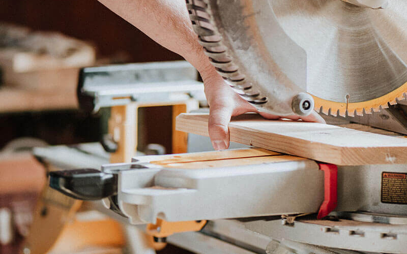 General contractor cutting wood with a chop saw
